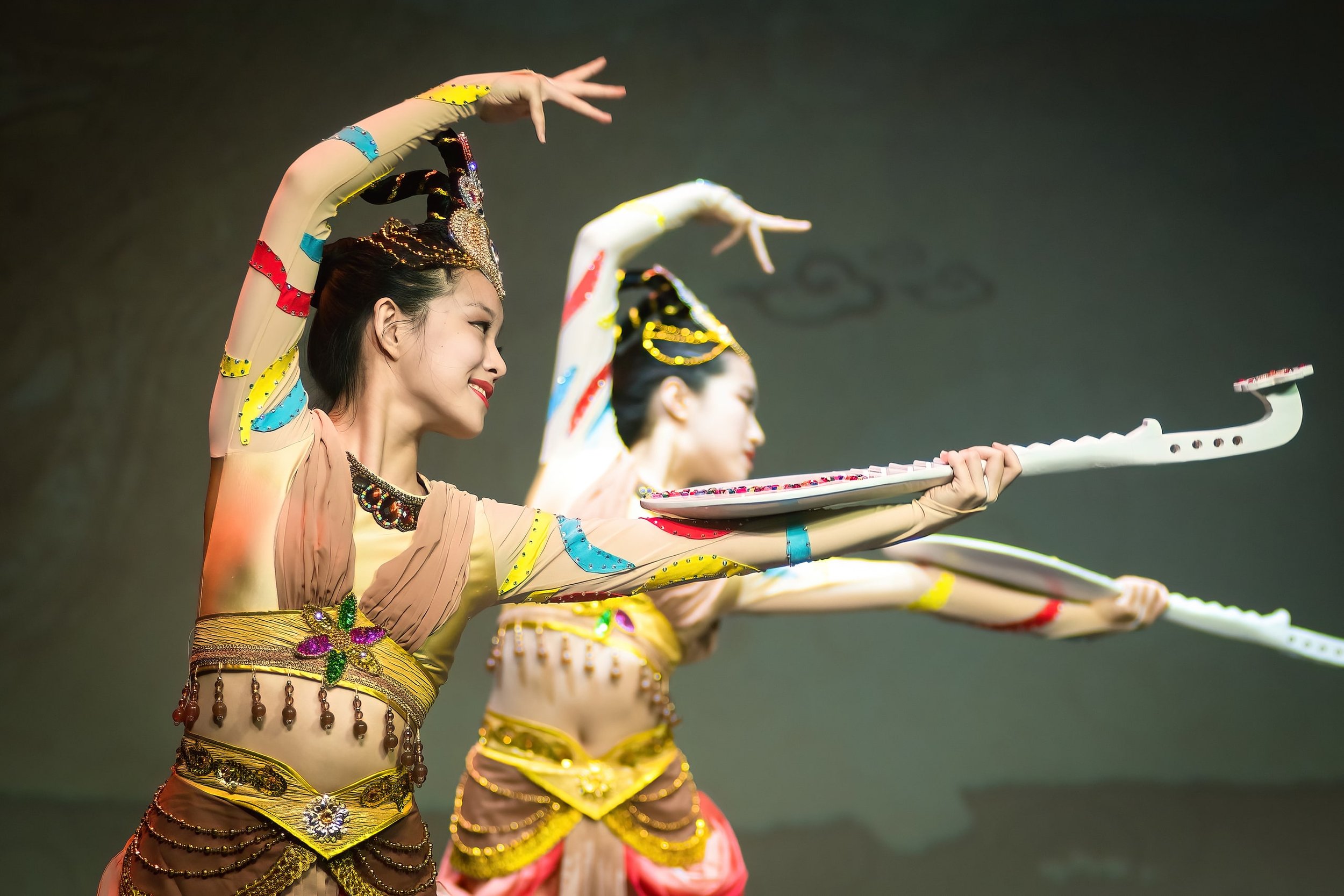 Two dancers performing a traditional Asian dance in costume.